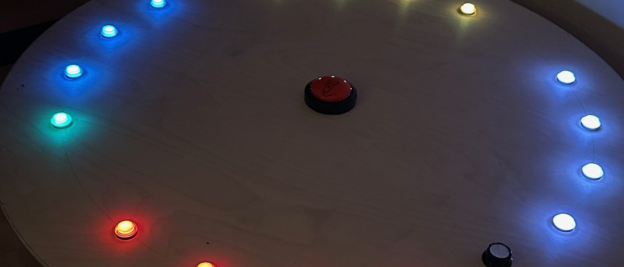 Der runde Tisch mit einem Ring aus farbigen Lichtern, im Dunkeln